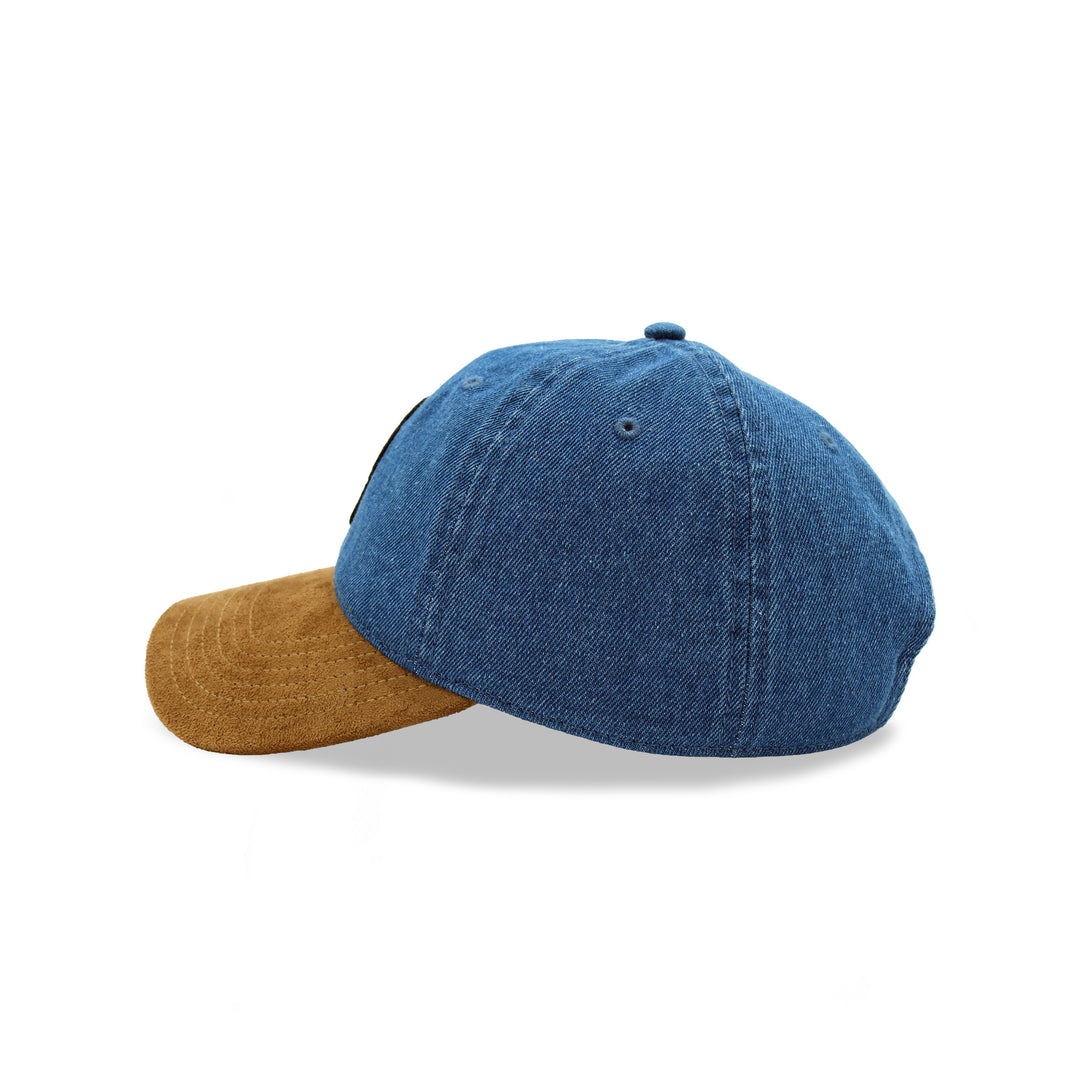 A baseball cap featuring a blue denim crown and a contrasting brown suede visor, shown from a side profile on a white background.