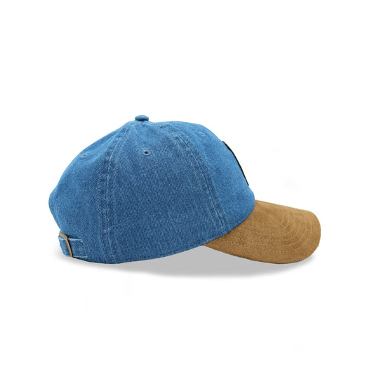 A baseball cap featuring a blue denim crown and a contrasting tan canvas brim, shown from a three-quarters angle on a white background.