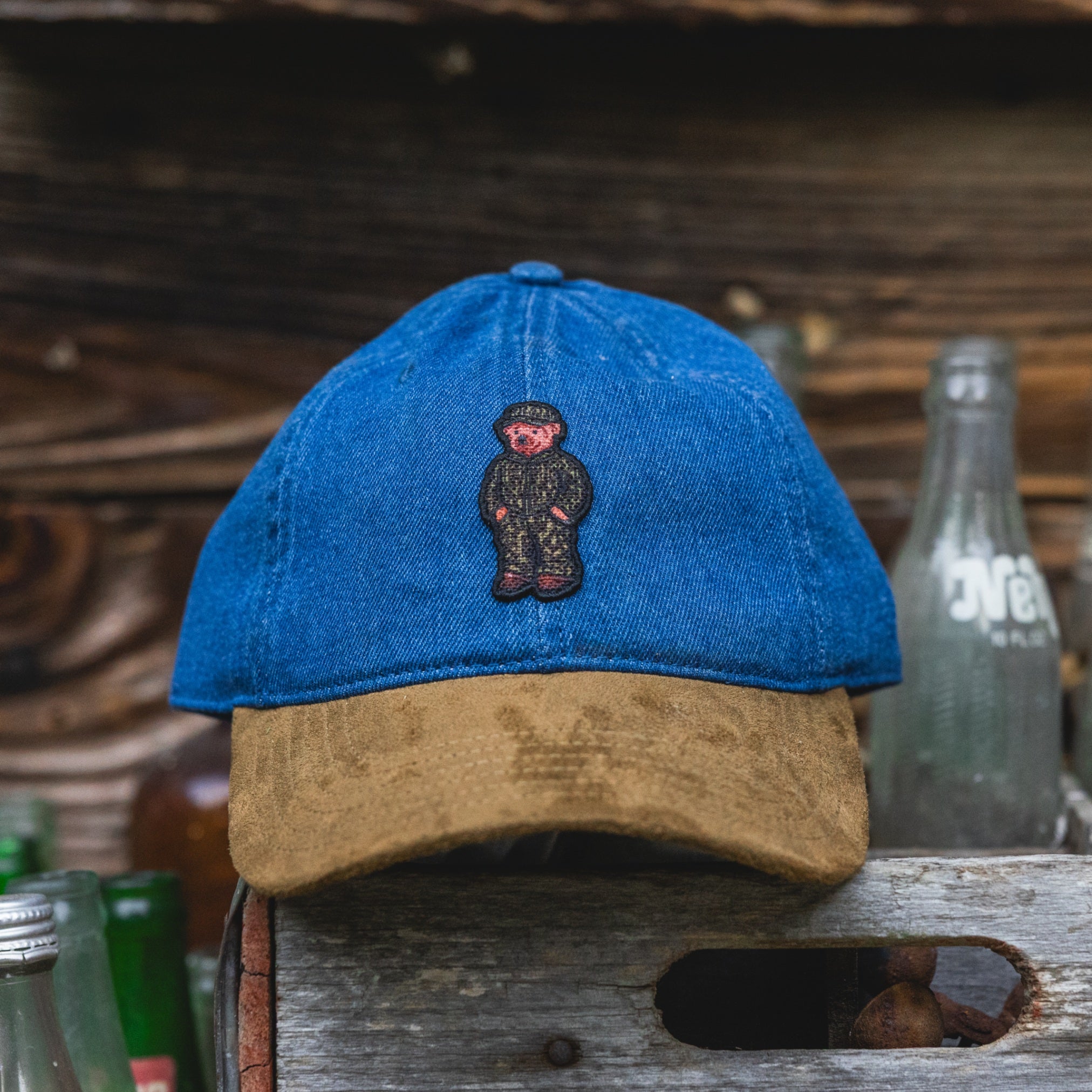 Denim dad hat with suede bill and embroidered bear patch on the front