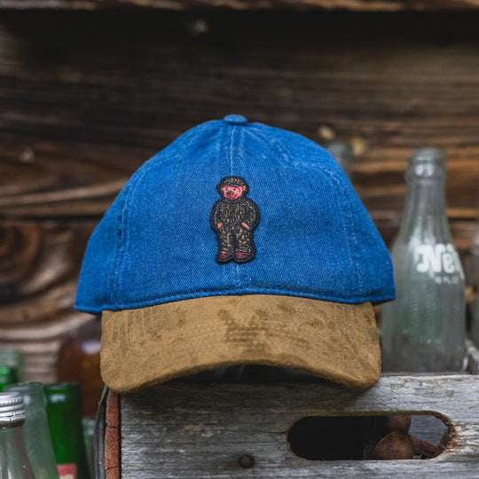 Denim dad hat with suede bill and embroidered bear patch on the front