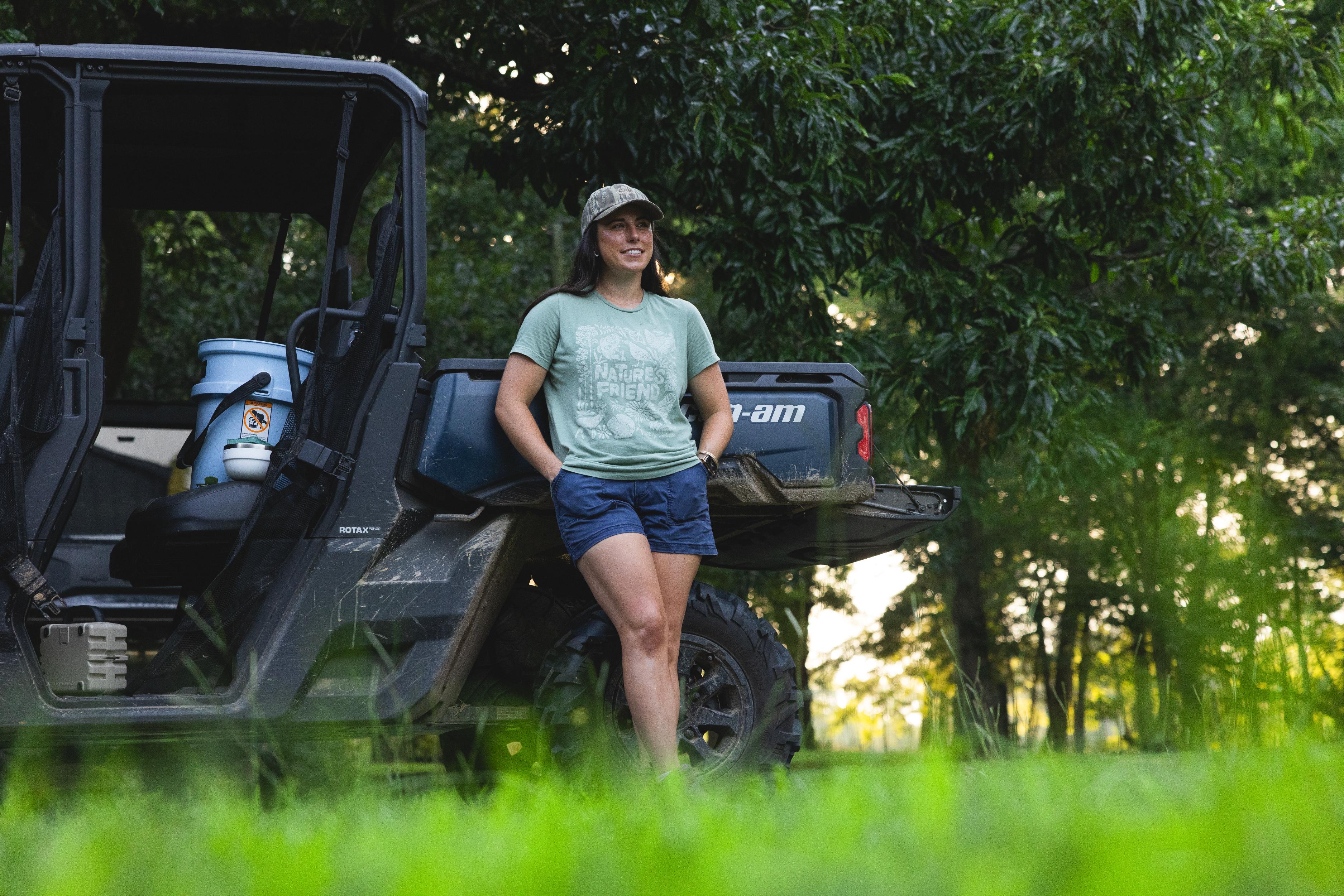 Macy Johnston standing near her can-am wearing a sage "Nature's Friend"